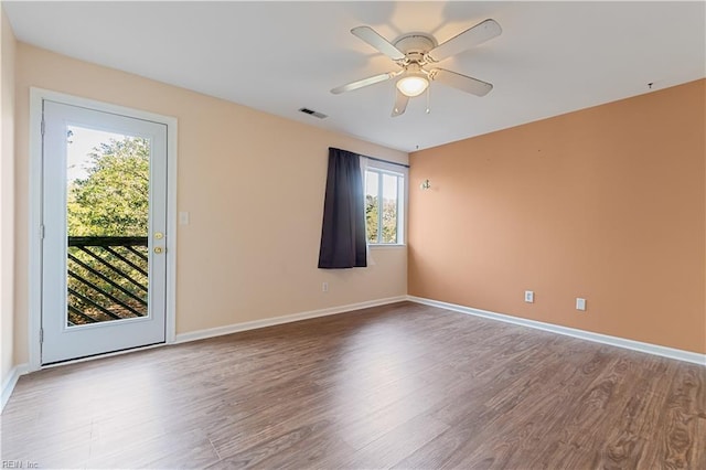 spare room with a wealth of natural light, hardwood / wood-style floors, and ceiling fan