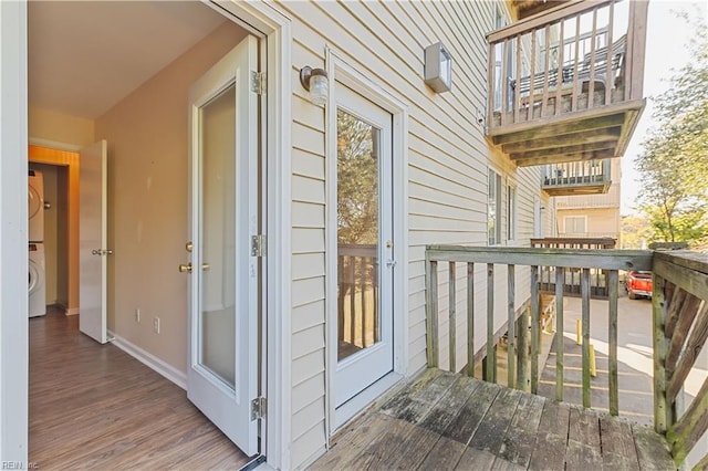 wooden deck featuring stacked washing maching and dryer