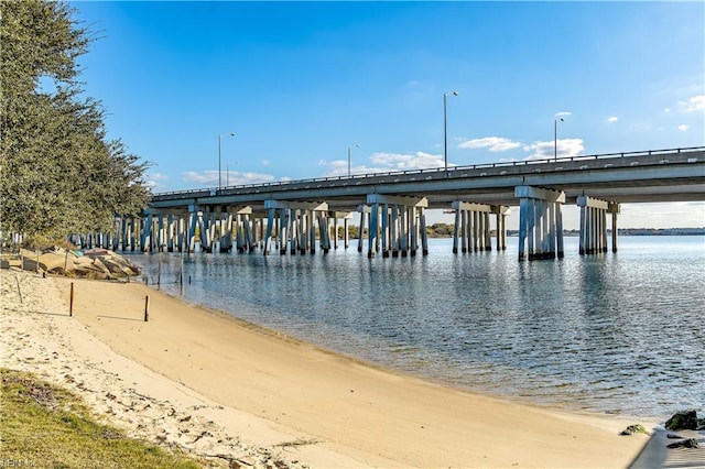 view of dock featuring a water view and a beach view