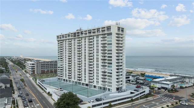 view of building exterior with a water view and a beach view