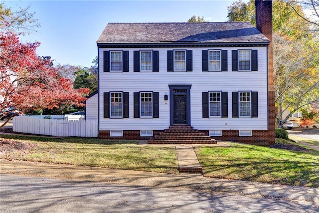 colonial-style house featuring a front lawn