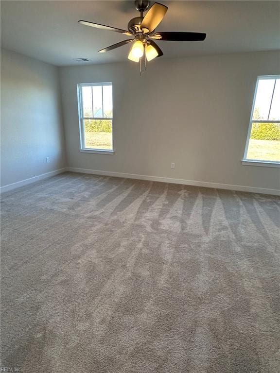 carpeted spare room with ceiling fan