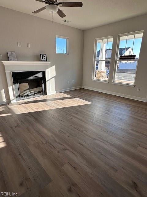 unfurnished living room featuring ceiling fan and dark hardwood / wood-style flooring