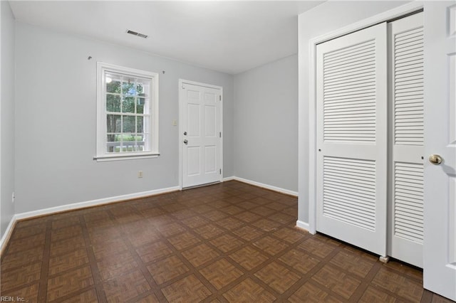 unfurnished bedroom with dark parquet floors