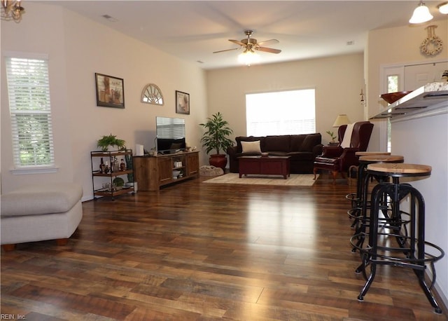 living room featuring a wealth of natural light, ceiling fan, and dark hardwood / wood-style floors