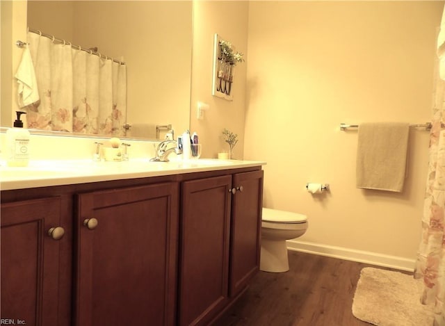 bathroom featuring wood-type flooring, vanity, and toilet