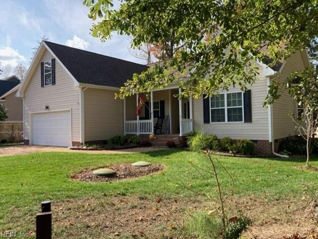 view of front facade with covered porch, a garage, and a front lawn