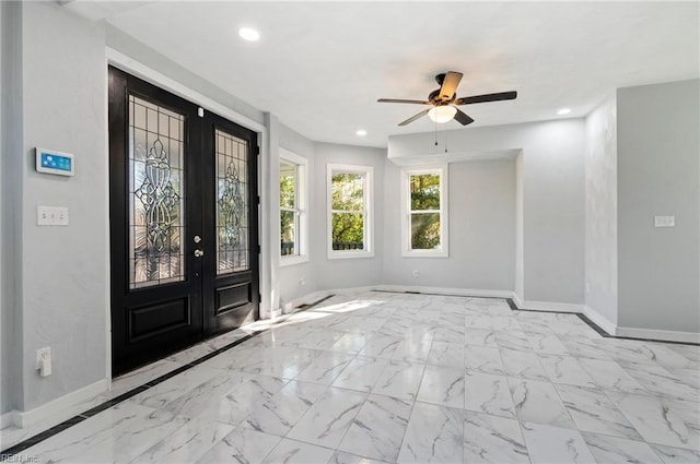 foyer entrance with ceiling fan and french doors