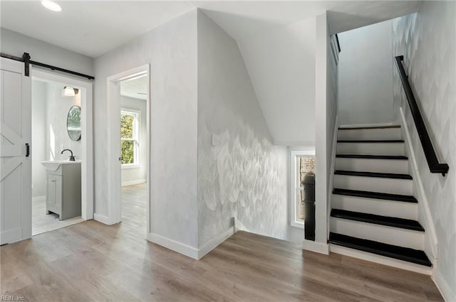 stairway with hardwood / wood-style floors and a barn door