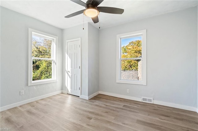 unfurnished bedroom with a closet, light hardwood / wood-style flooring, multiple windows, and ceiling fan