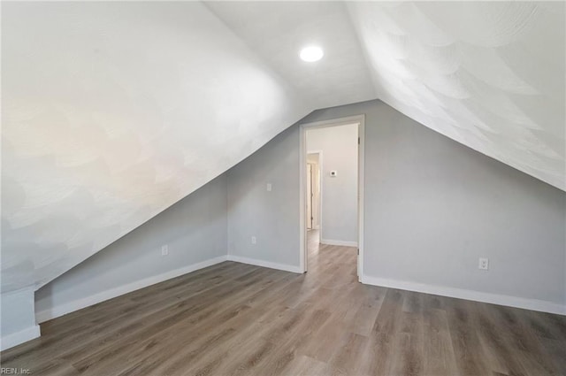 bonus room with lofted ceiling and wood-type flooring