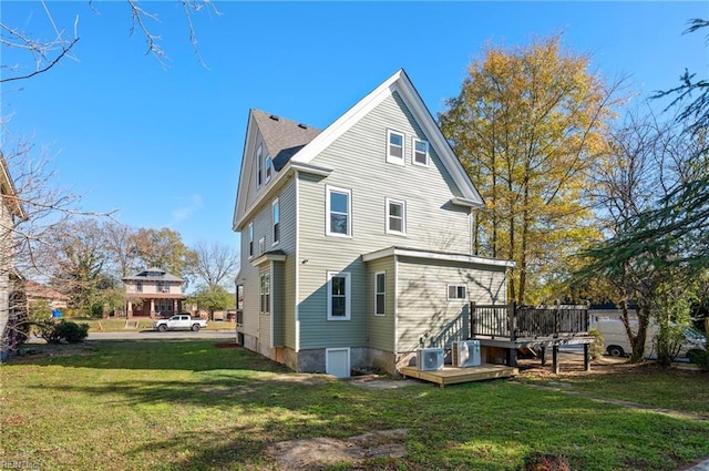 rear view of property featuring a deck and a lawn