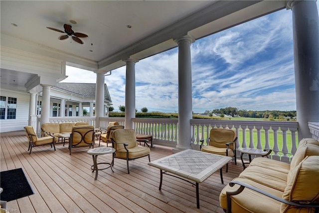 wooden deck with outdoor lounge area and ceiling fan