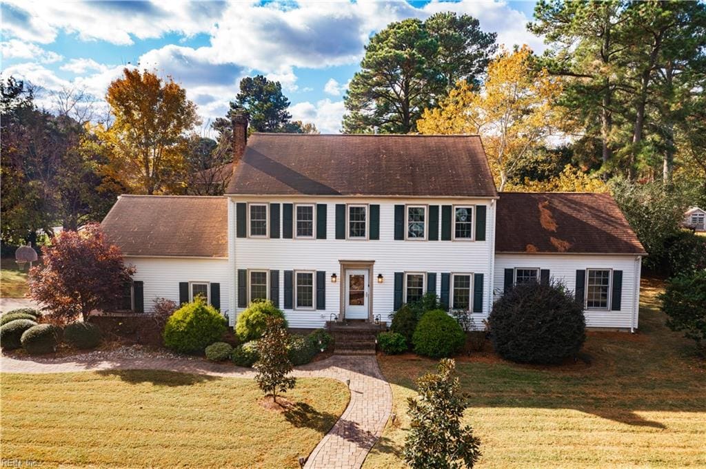 colonial inspired home featuring a front lawn