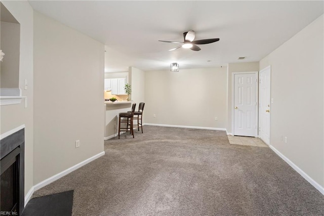 unfurnished living room featuring ceiling fan and light carpet