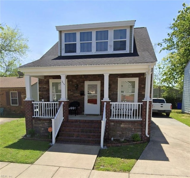 view of front of house with a porch and a front lawn