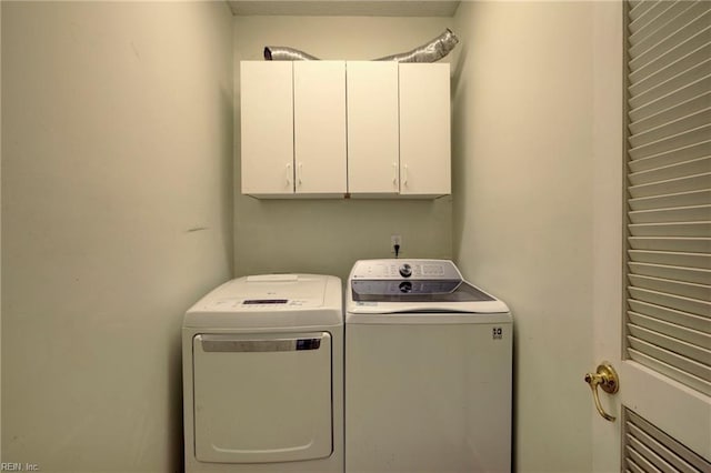 laundry room featuring cabinets and washing machine and dryer