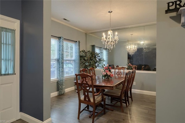 dining area with dark hardwood / wood-style floors, ornamental molding, and a notable chandelier