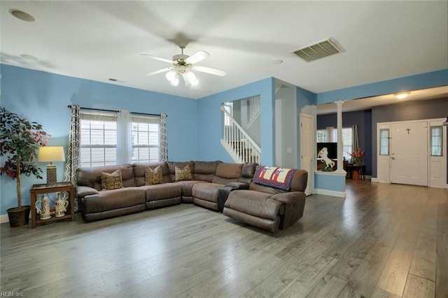 living room featuring decorative columns, ceiling fan, and hardwood / wood-style flooring