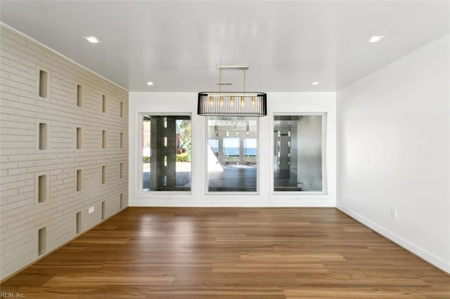 interior space with hardwood / wood-style floors and brick wall