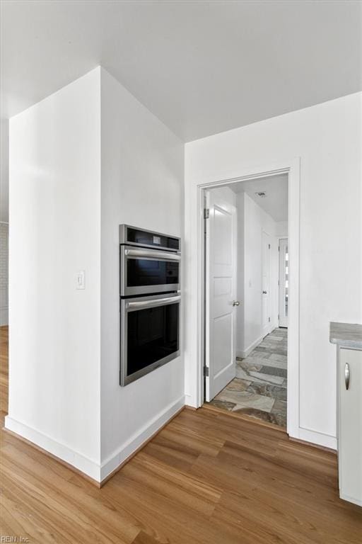 kitchen with wood-type flooring and double oven