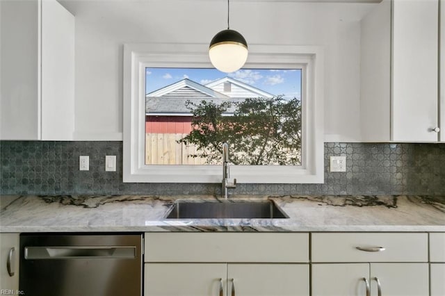 kitchen featuring white cabinets, stainless steel dishwasher, plenty of natural light, and sink