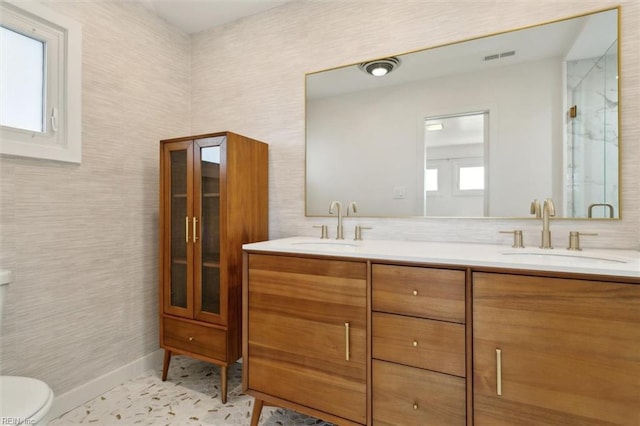 bathroom featuring tile patterned flooring, vanity, toilet, and a shower with shower door