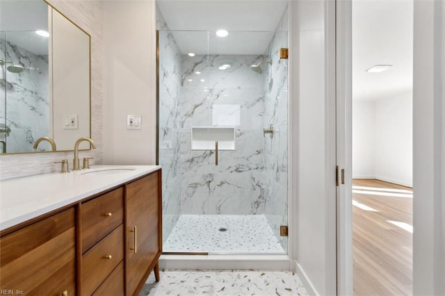 bathroom with a shower with door, vanity, and wood-type flooring