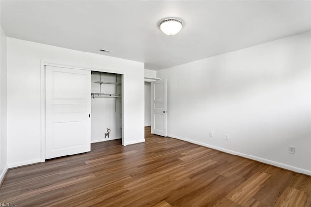 unfurnished bedroom featuring dark hardwood / wood-style flooring and a closet