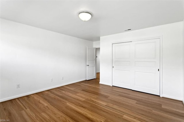 unfurnished bedroom featuring hardwood / wood-style floors and a closet