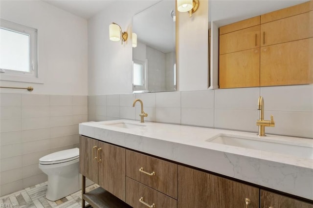 bathroom with tile patterned floors, plenty of natural light, vanity, and tile walls