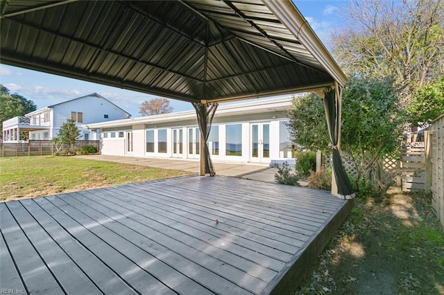 wooden deck with a lawn and french doors