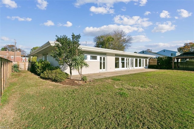 rear view of house with a lawn, a gazebo, and french doors