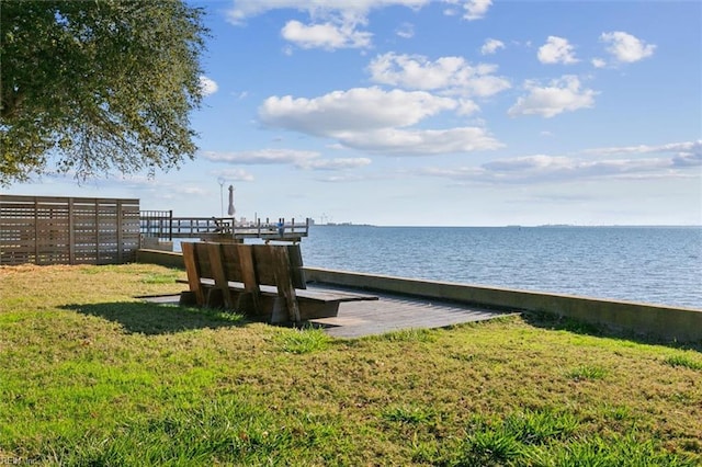 view of dock with a water view and a yard