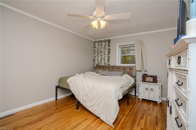 bedroom featuring ceiling fan, wood-type flooring, and ornamental molding