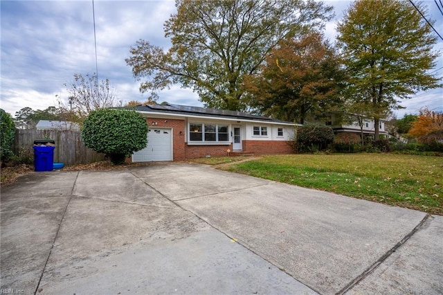 single story home with a garage, a front yard, and solar panels