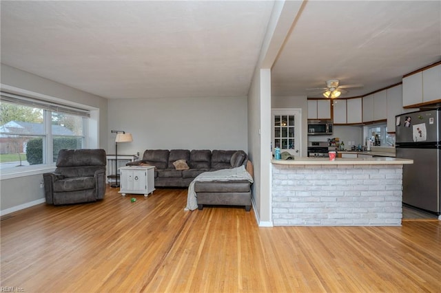 living room with ceiling fan and light wood-type flooring