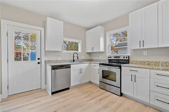 kitchen featuring appliances with stainless steel finishes, white cabinetry, and a healthy amount of sunlight