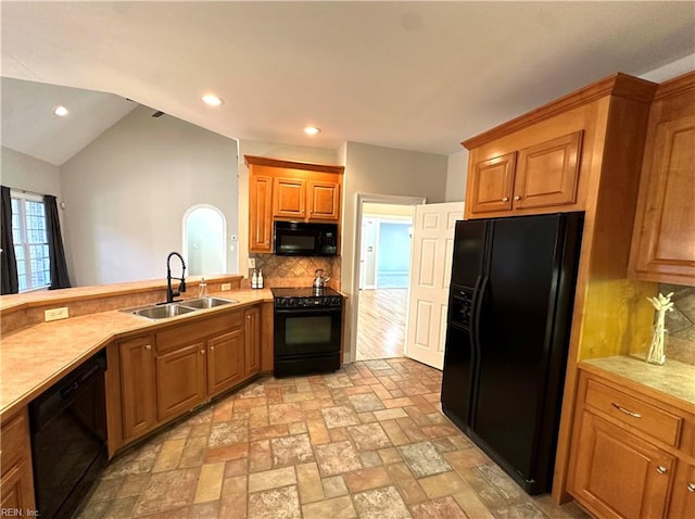 kitchen featuring black appliances, decorative backsplash, sink, and vaulted ceiling