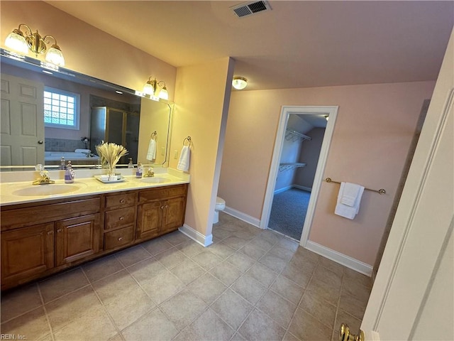 bathroom with a bathing tub, tile patterned flooring, toilet, and vanity