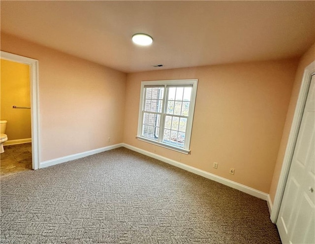 unfurnished bedroom featuring carpet and connected bathroom