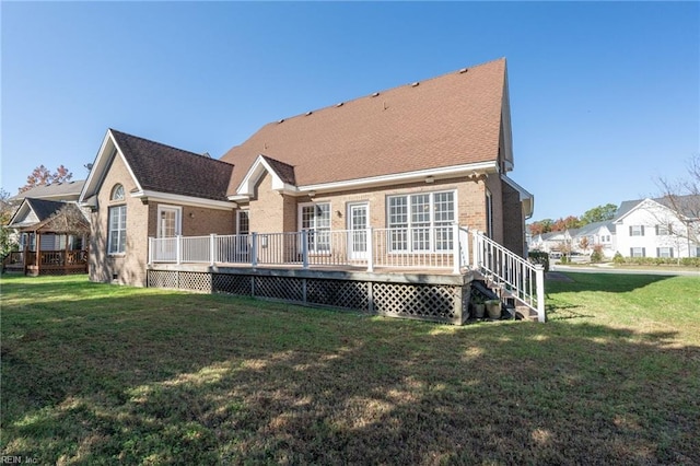 rear view of house with a yard and a wooden deck