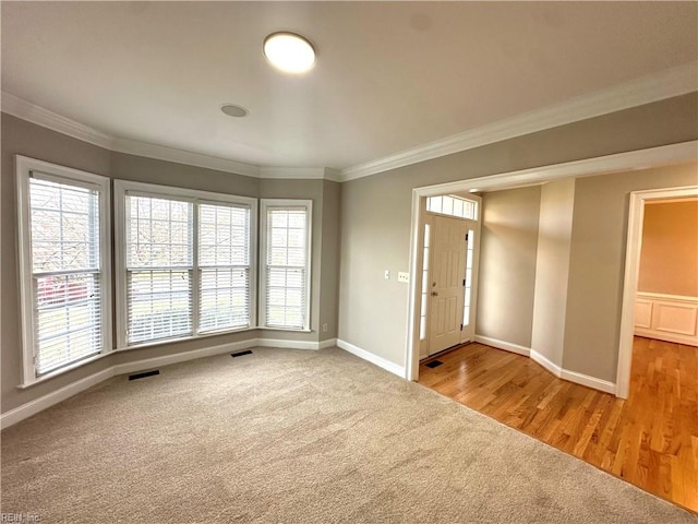 spare room featuring ornamental molding and hardwood / wood-style flooring