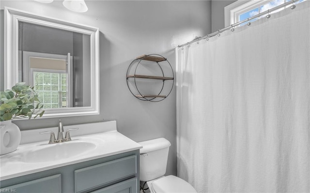 bathroom with plenty of natural light, vanity, and toilet