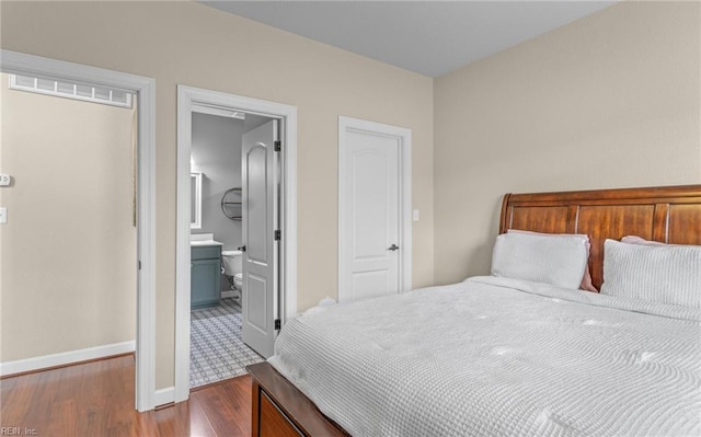 bedroom with hardwood / wood-style flooring and ensuite bath