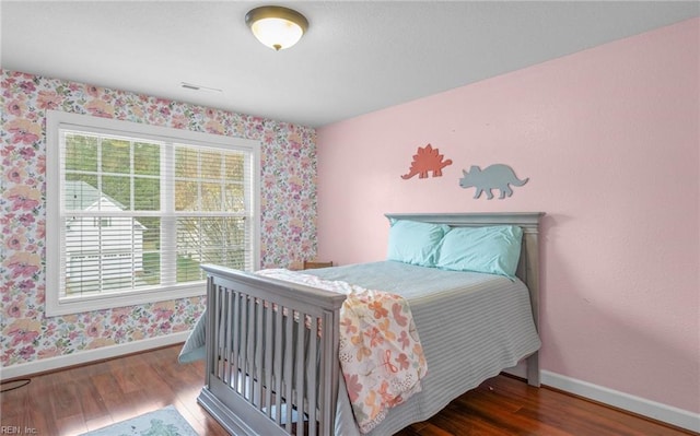 bedroom with dark hardwood / wood-style floors