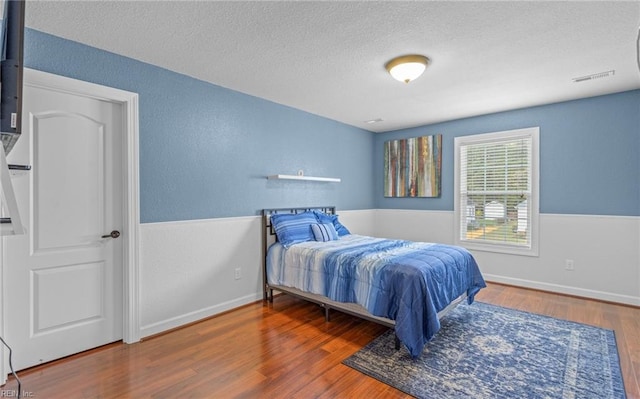 bedroom featuring hardwood / wood-style floors and a textured ceiling