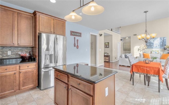 kitchen featuring a notable chandelier, a kitchen island, stainless steel fridge with ice dispenser, and hanging light fixtures