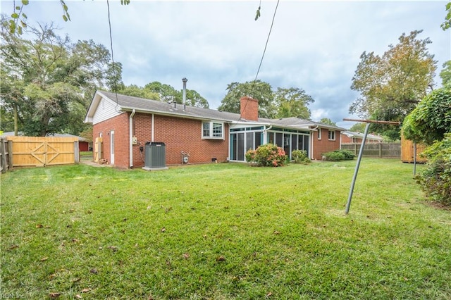 back of house with a yard, central air condition unit, and a sunroom