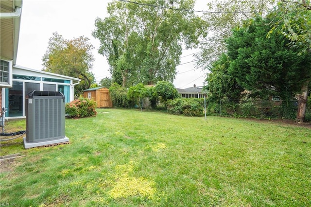 view of yard featuring central AC unit and a shed